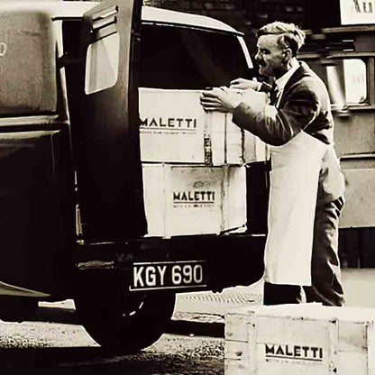 Mann lädt Kisten in Lieferwagen.