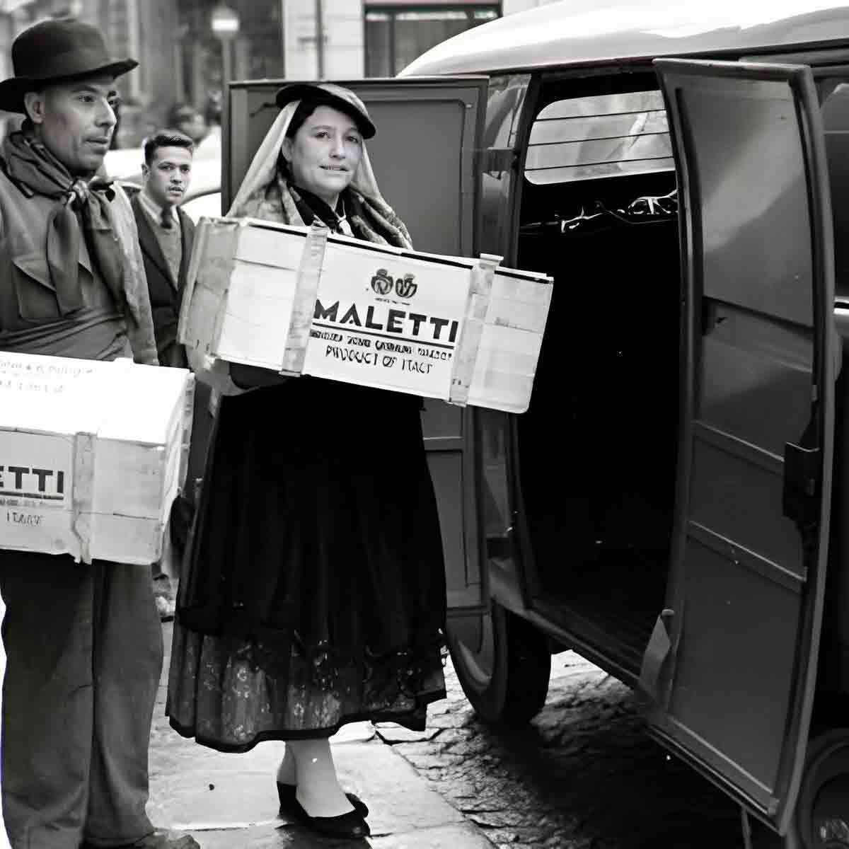 Personen laden Maletti-Kisten in ein Fahrzeug.