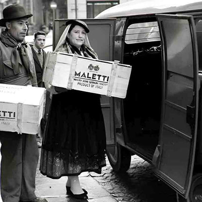 Personen laden Maletti-Kisten in Fahrzeug auf der Straße.
