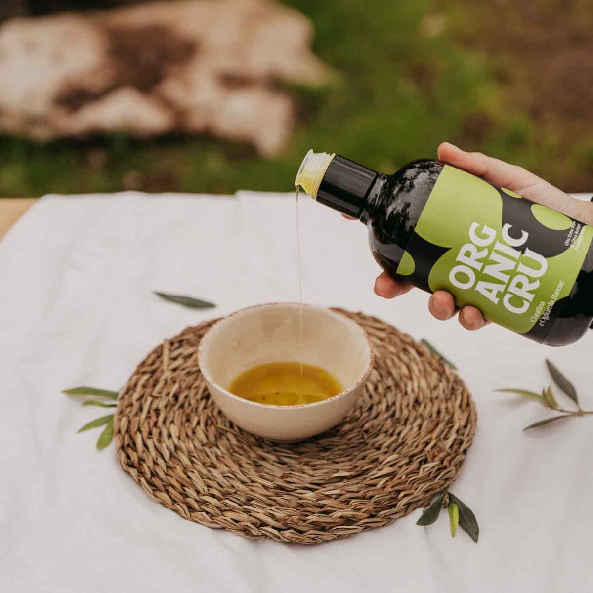 Olivenöl wird in eine Schale auf Tisch gegossen.