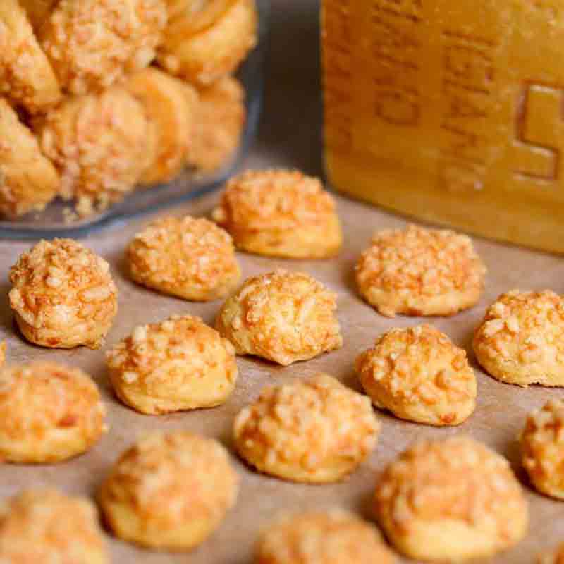 Käsegebäck auf Backpapier verteilt.