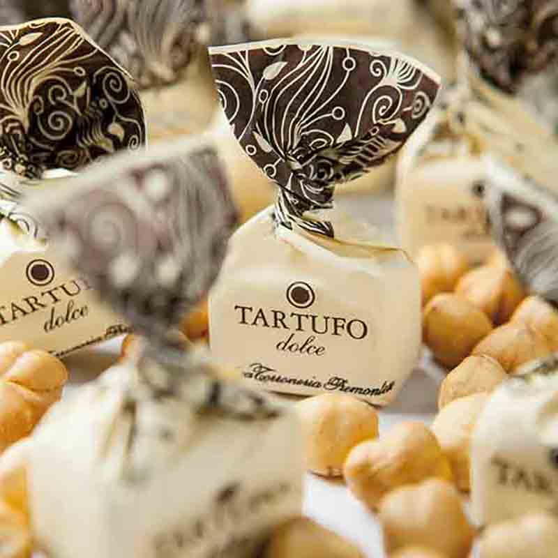 Tartufo dolce Pralinen umgeben von Haselnüssen.
