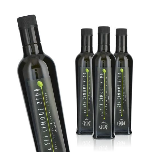 Vier Flaschen Crudo Olivenöl, Etikett sichtbar.