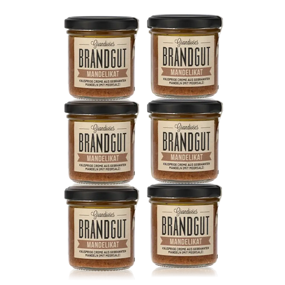Sechs Gläser Brandgut Mandelikat Feinkost mit Etiketten.