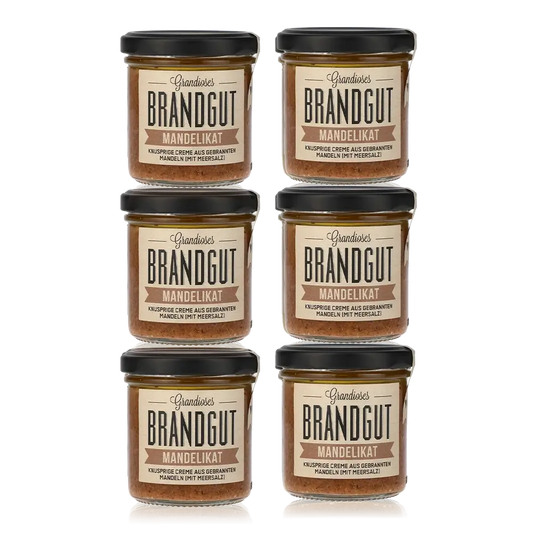 Sechs Gläser Brandgut Mandelikat Feinkost mit Etiketten.