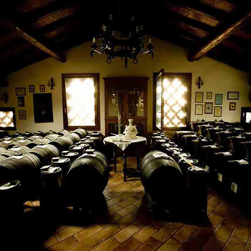 Weinfässer in rustikalem Raum mit Holzboden und Dekorationen.