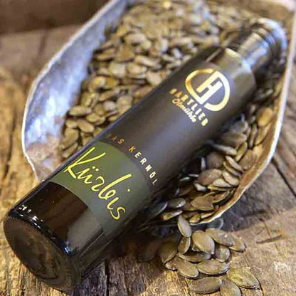 Hartlieb Kürbiskernöl-Flasche auf Kürbiskernen in Schale.