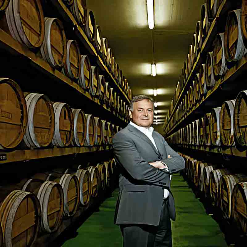 Alois Gölles, Eigentümer der Gölles Essigmanufaktur, steht zwischen Fässern mit Essig-Spezialitäten.