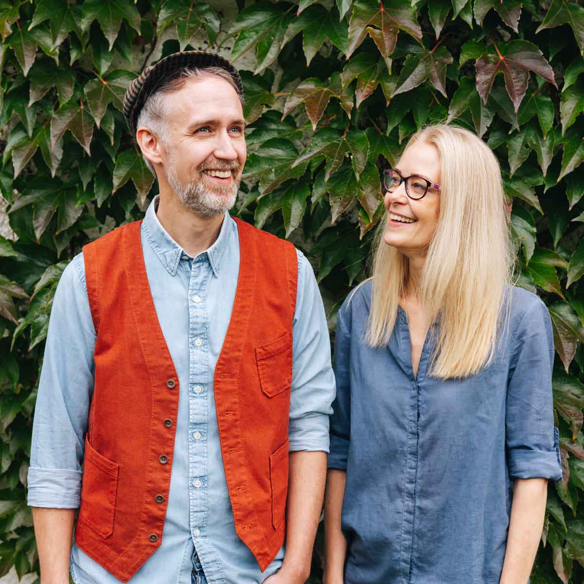 Zwei Personen vor Efeu-Wand.