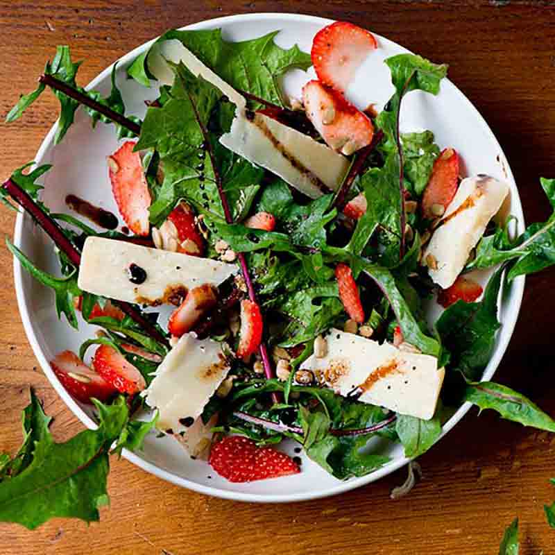 Salat mit Käse, Erdbeeren, Nüssen und Balsamico-Dressing.