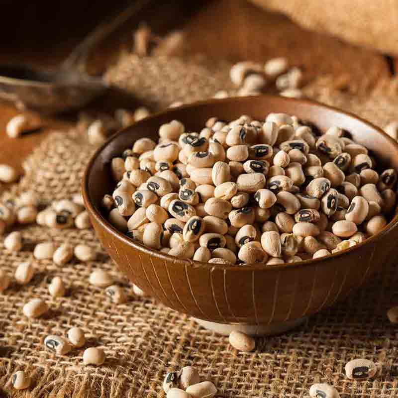 Schüssel mit Augenbohnen auf Tisch.