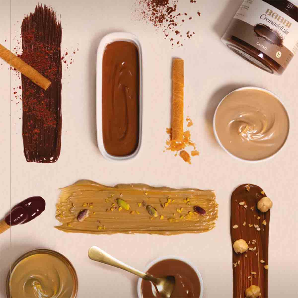 Verschiedene Babbi Cremadelizia Aufstriche und Dekorationen auf Tisch.