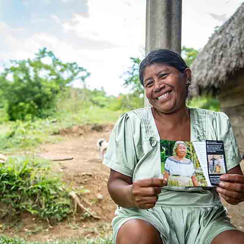 Stolze Kakaobäuerin mit Zotter-Flyer – direkter Handel unterstützt faire Einkommen und nachhaltigen Kakaoanbau.