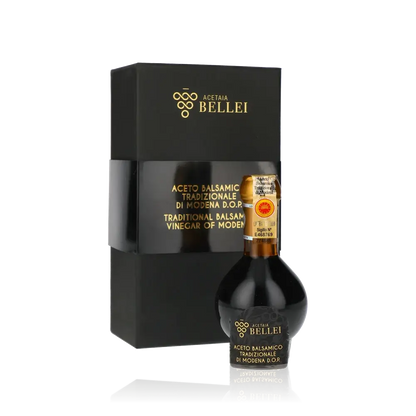 Aceto Balsamico Bellei Flasche und Verpackung vor schwarzem Hintergrund.