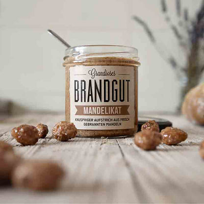 Glas Brandgut Mandelikat mit Mandeln auf Holztisch.