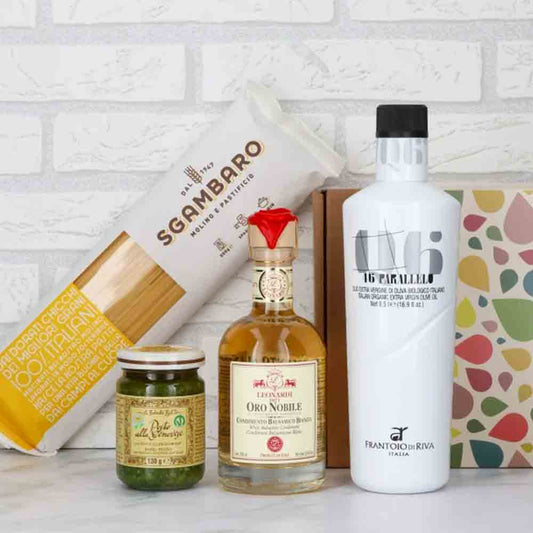 Olivenöl, Essig, Pasta, Pesto, Geschenkbox vor weißer Wand.