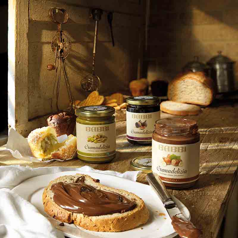 Cremadelizia Brotaufstriche auf Tisch mit Brot und Gebäck.