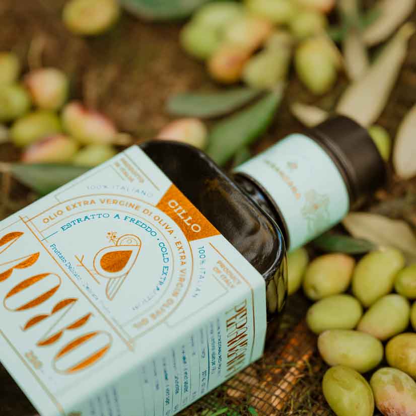 Francesco Cillo Olivenöl liegt auf grünen Oliven.