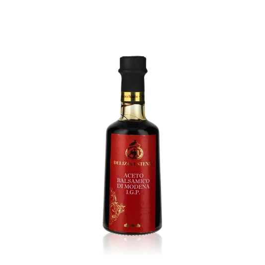 Delizia Estense Balsamico Essigflasche vor schwarzem Hintergrund.