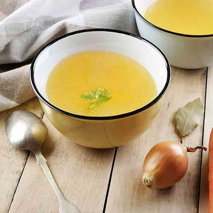 Schale mit Brühe und Zwiebel.