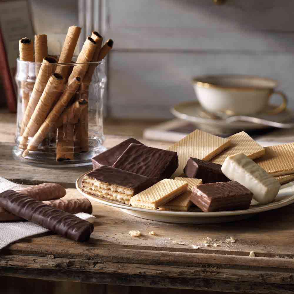 Feinkostgebäck und Waffeln auf einem Tisch mit Tasse.