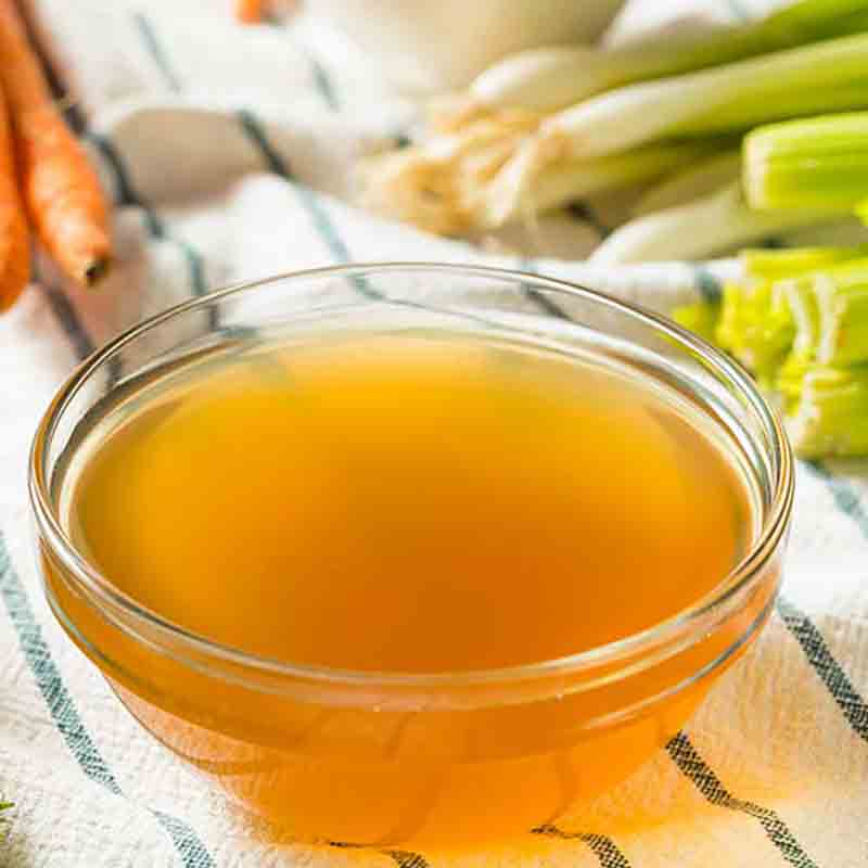 Schüssel mit klarer Gemüsebrühe.