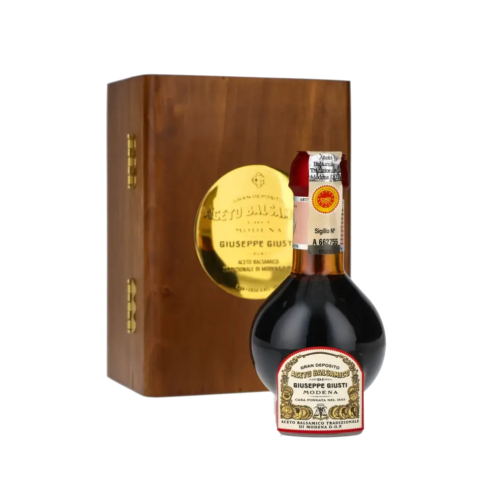 Giuseppe Giusti Balsamico-Essigflasche vor Holzkiste.