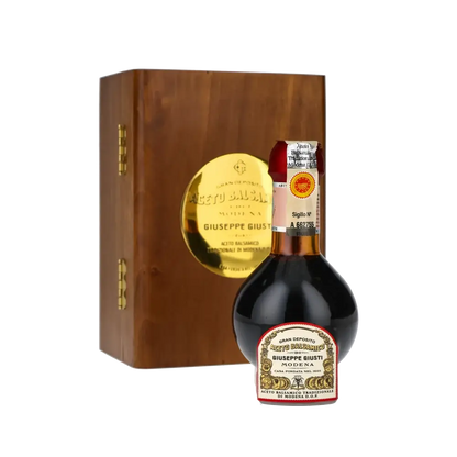 Giuseppe Giusti Balsamico-Essigflasche vor Holzkiste.