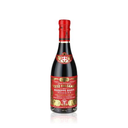 Giuseppe Giusti Aceto Balsamico Flasche vor schwarzem Hintergrund.