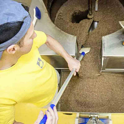 Ein Mitarbeiter füllt die Pressanlage mit Rohstoffen.