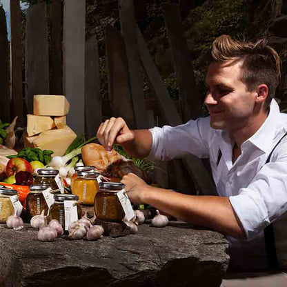 Feinkostprodukte und Mann an einem Tisch im Freien.