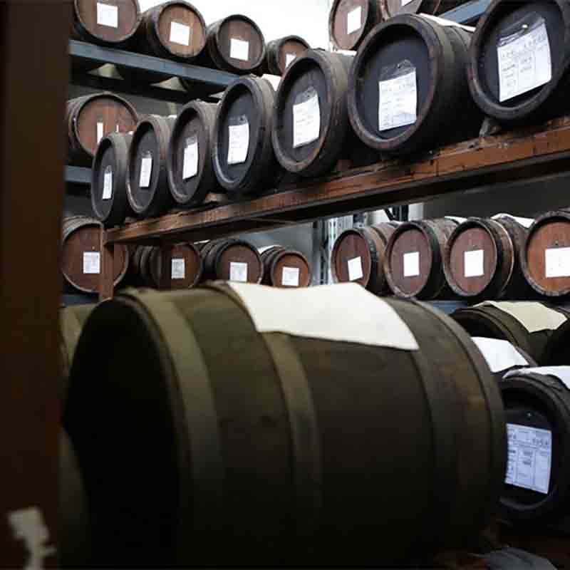 Holzfässer mit Essig in einem Lagerraum, Marke Mussini.