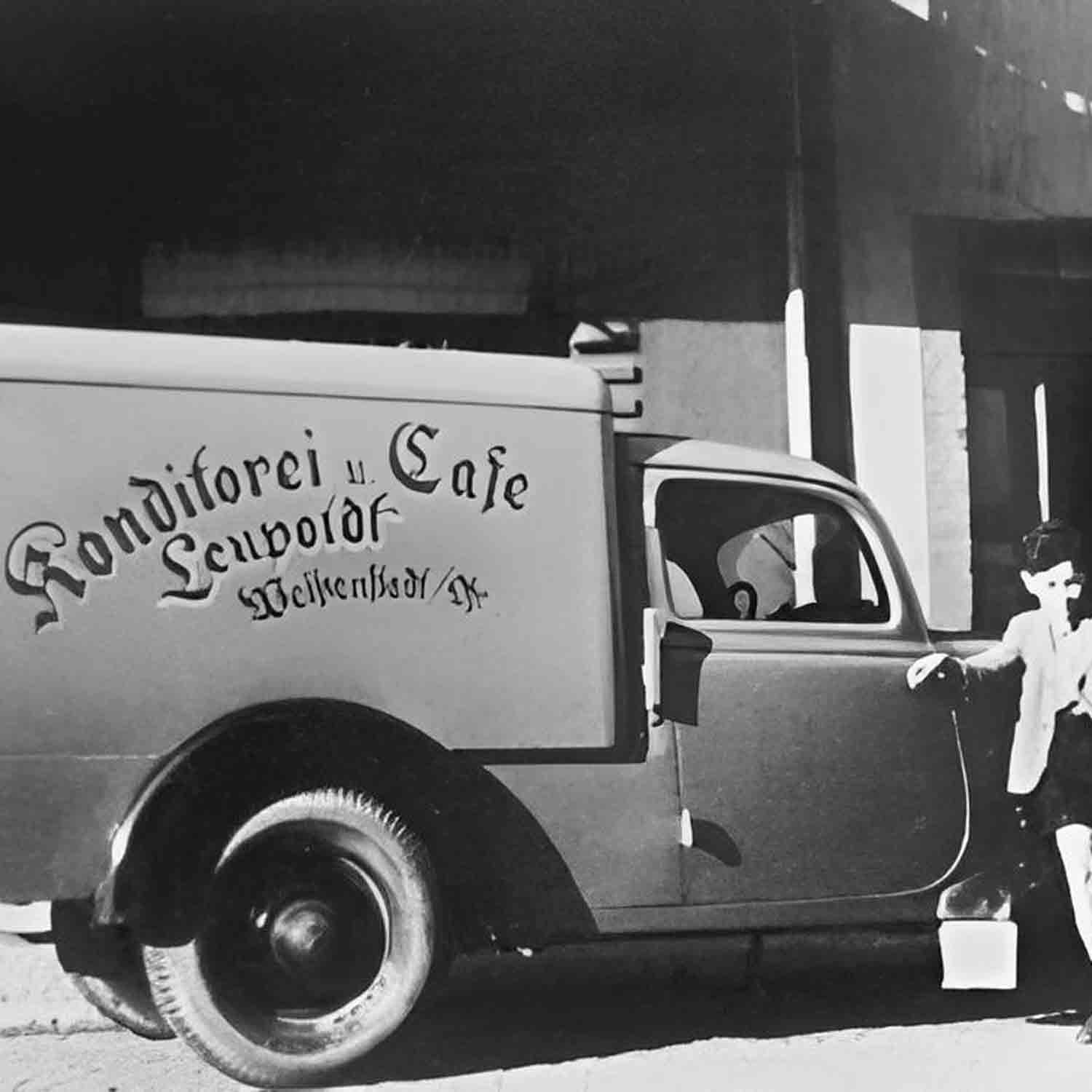 Lieferwagen vor Konditorei, historische Aufnahme.