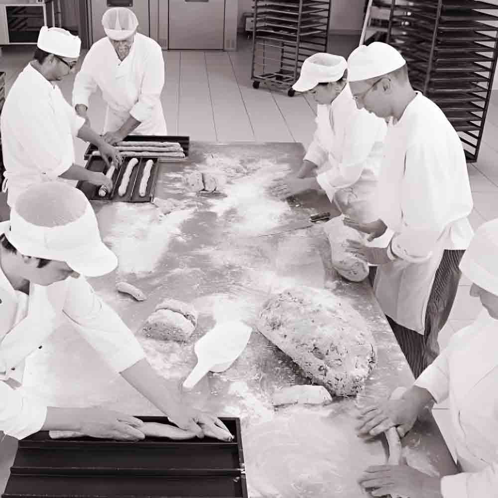 Bäcker formen Teig in Bäckerei.