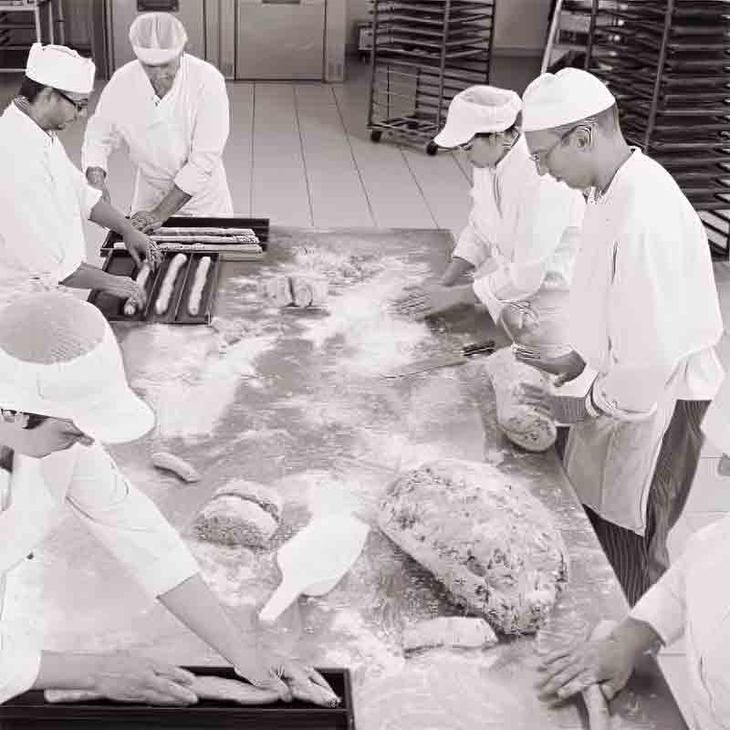 Bäcker formen Teig in Bäckerei.