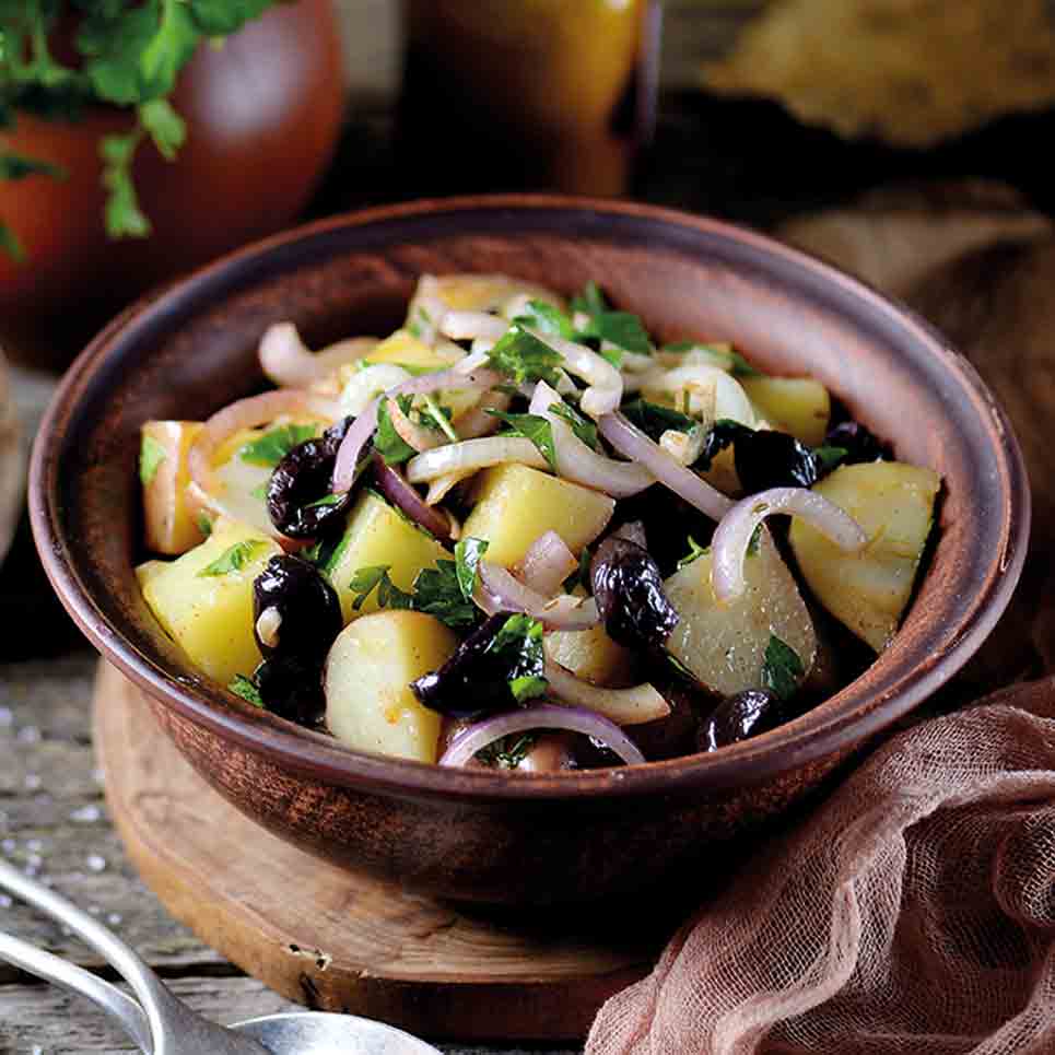 Mediterraner Kartoffelsalat mit Oliven, Zwiebeln und Kräutern.