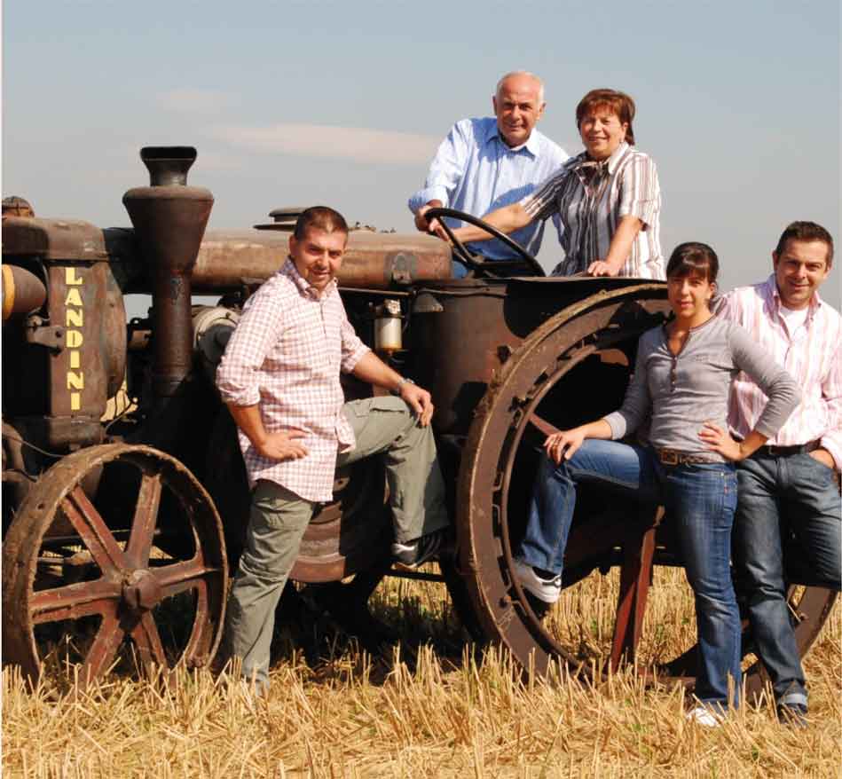 Gruppe posiert vor Traktor.