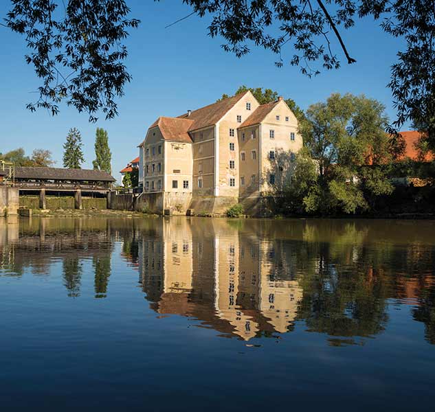 Historische Mühle am Flussufer.