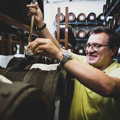 Herstellung von hochwertigem Balsamessig in traditionellen Holzfässern. Essigmeister prüft die Qualität.