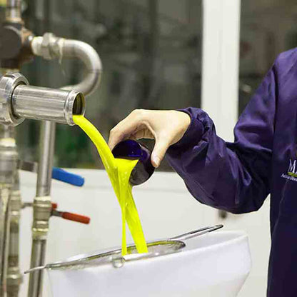 Person füllt frisches Olivenöl in Behälter.