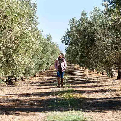 Paola Garcia läuft zwischen den Olivenbäumen.