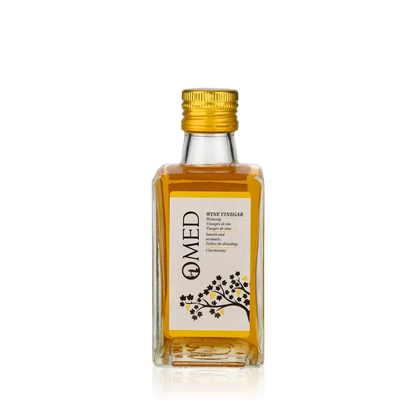 O-MED Chardonnay Weißweinessig Flasche vor schwarzem Hintergrund.