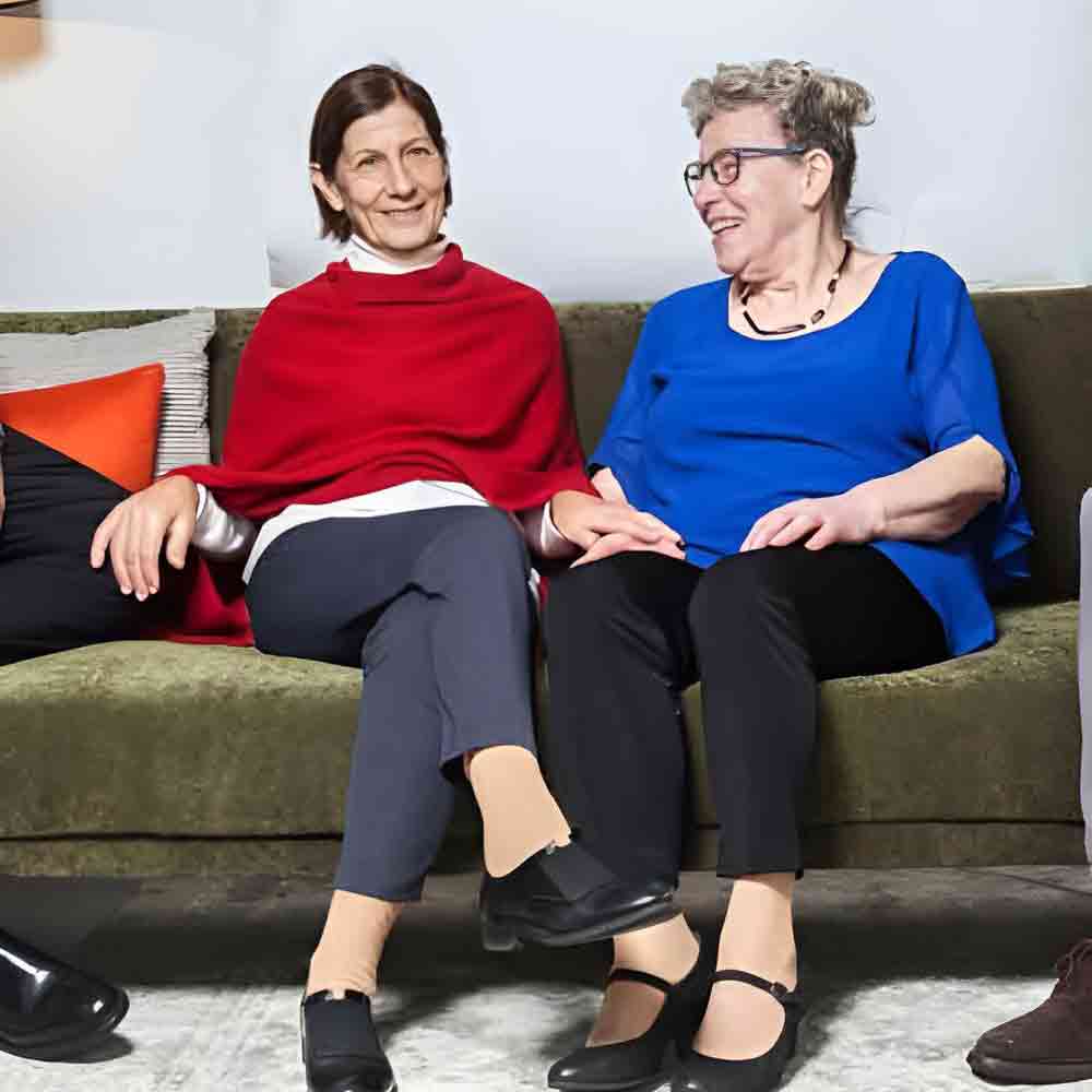 Zwei Frauen sitzen auf Sofa.
