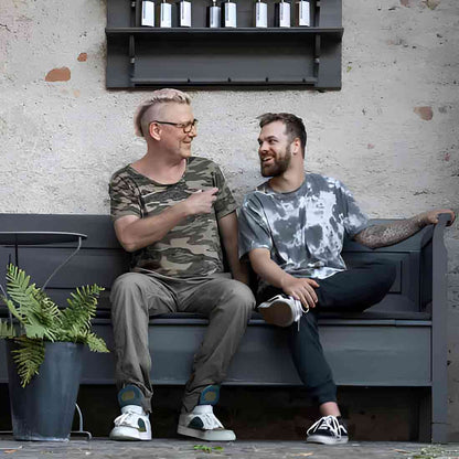 Zwei Männer sitzen auf Bank.