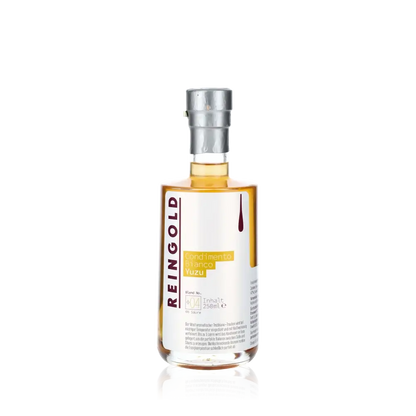 Reingold Condimento Bianco Yuzu Flasche vor schwarzem Hintergrund.