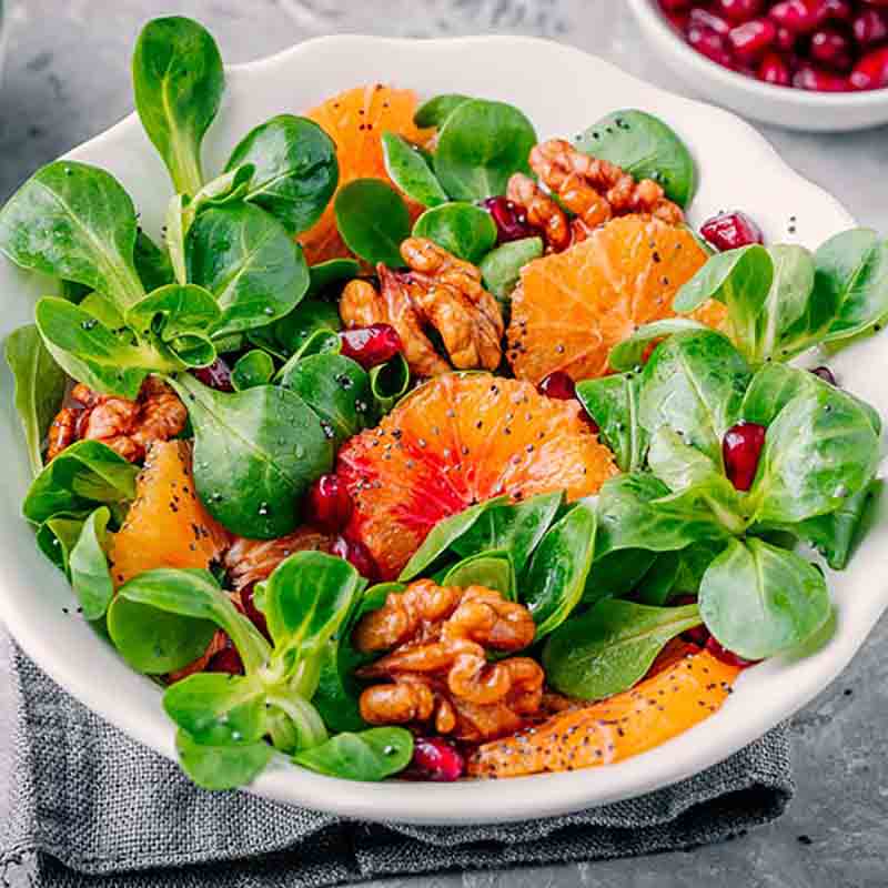 Salat mit Feldsalat, Orangen, Walnüssen und Granatapfelkernen.