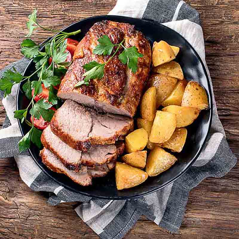 Schweinebraten mit Kartoffeln und Petersilie.