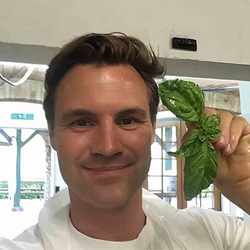 Person mit Basilikum in Hand.