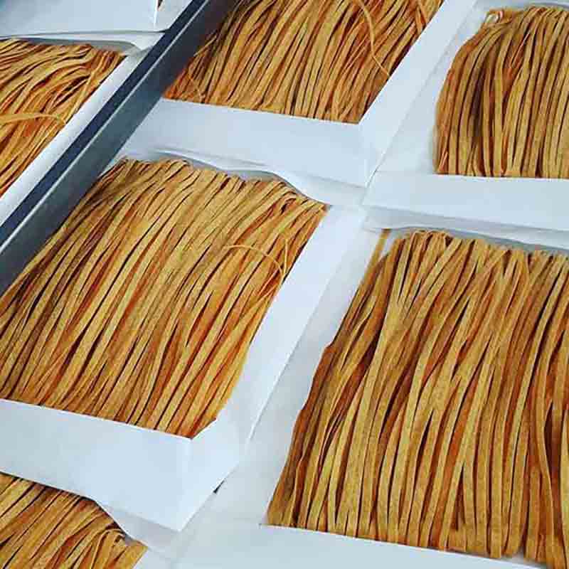 Steinpilz-Taglioni-Nudeln in Verpackungen aufgereiht.