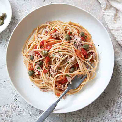 Pasta mit Tomatensauce, Kapern und Thunfisch auf Teller.